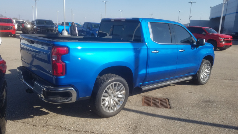 Blue 2022 Chevrolet Silverado pickup seen from right rear parked in a Chevy dealer lot