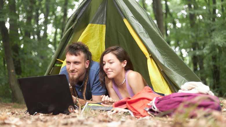 couple watching tv in a tent