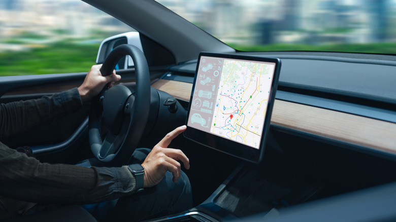 A person using a car's touchscreen while driving