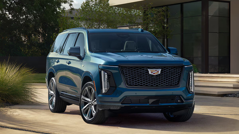 2025 blue escalade parked in front of a modern bulding