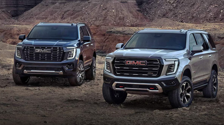 Two 2025 GMC Yukons parked in a rugged quarry or mine setting
