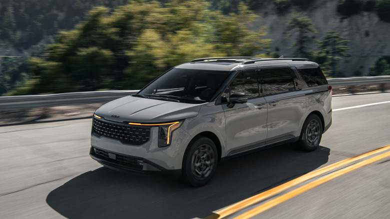 2025 Kia Carnival parked in an urban setting, showcasing its modern design and spacious profile.