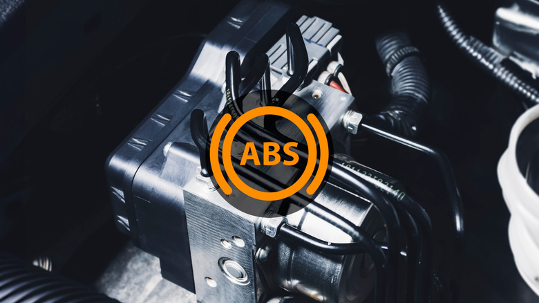 Close-up of an anti-lock braking system (ABS) module inside a car engine bay with an overlaid ABS warning icon in orange.