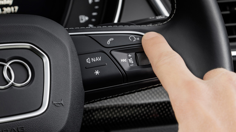 Audi driver pressing voice control button