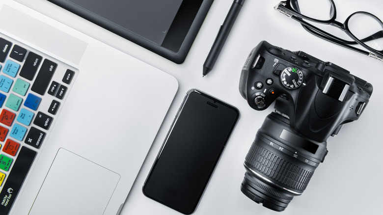 Photographer holding a DSLR camera in home office