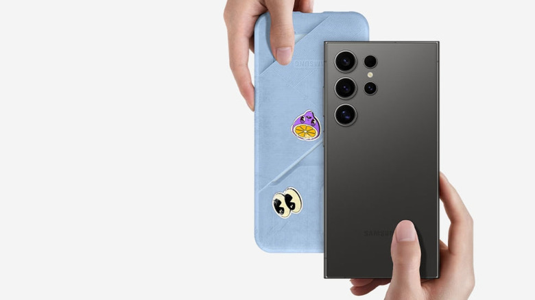 Two hands exchanging Samsung smartphones.