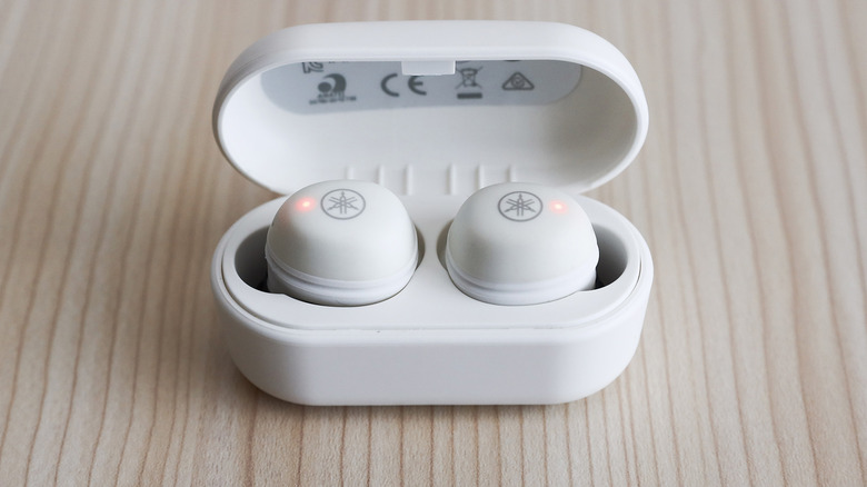 A pair of Yamaha earbuds on a wood table