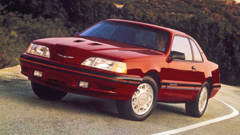 Red 1988 Ford Thunderbird Turbo Coupe seen from front left on mountain road