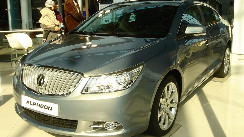 Silver Alpheon sedan seen from left front in a showroom