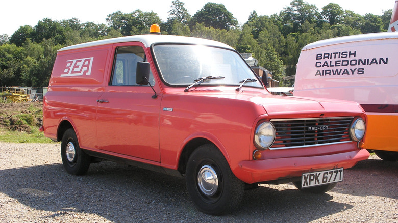 Red 1978 Bedford HA van seen from front right parked next to another van