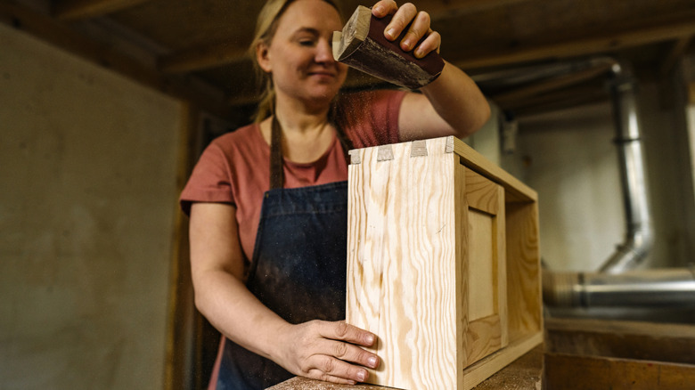 Person sanding wooden drawer