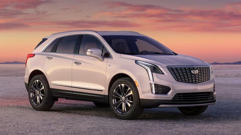 A white Cadillac XT5 in front of a scenic view.