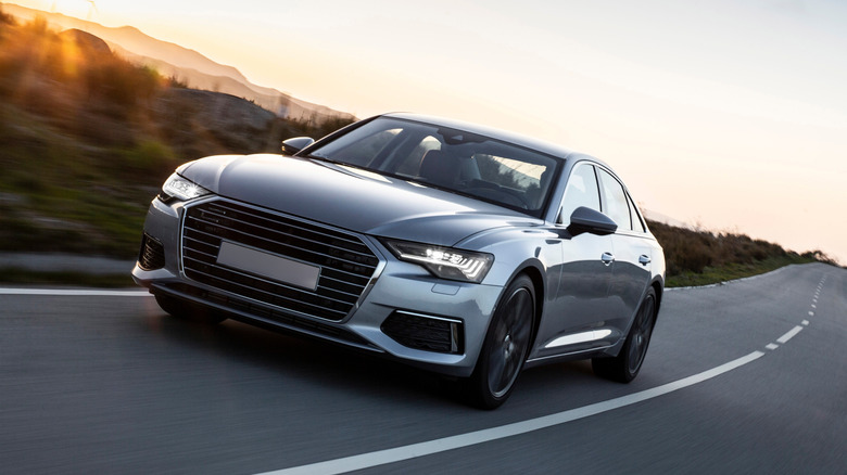 A luxury car being driven down a road.