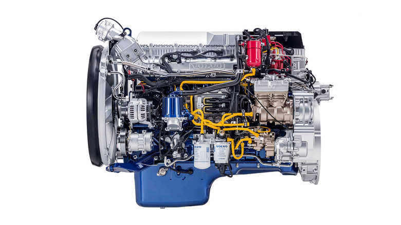 A silver and blue Volvo G13C LNG truck engine, side view