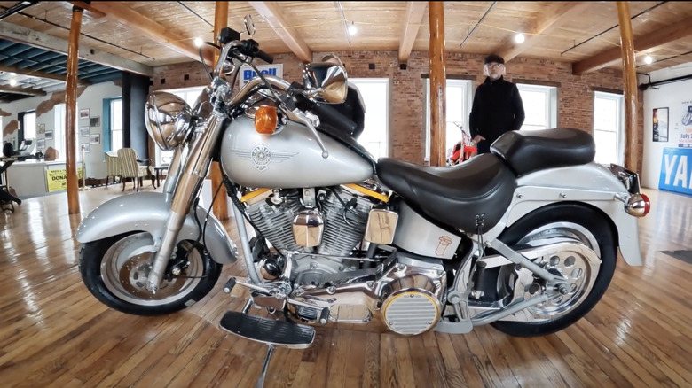 A beautiful silver and chrome 1990 Harley Softail Fat Boy parked inside at a motorbike museum