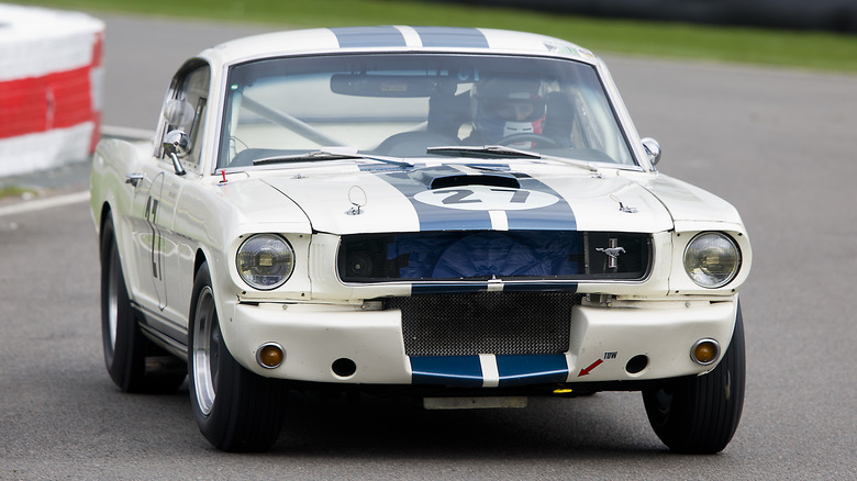 A white and blue 1965 Ford Shelby Mustang GT350R on track