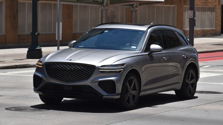 A gray Genesis GV70 driving in the city