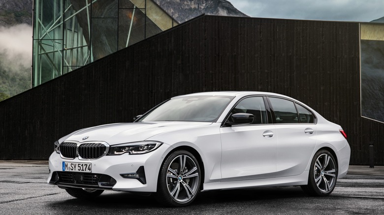 White BMW 3 Series Sedan parked in front of a building