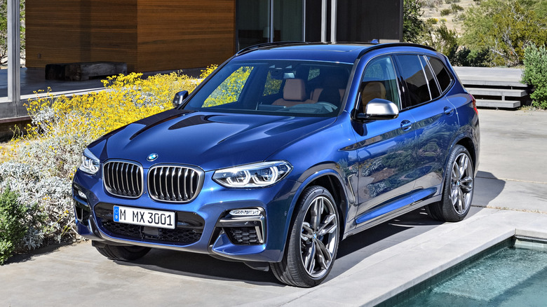 Blue BMW X3 parked in front of a building