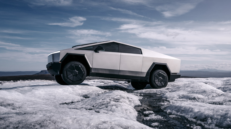 Tesla Cybertruck seen from the left crossing an icy stream