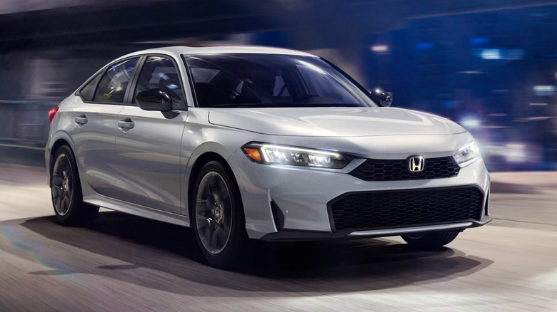 A white Honda Civic sedan driving