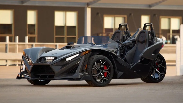 Black Polaris Slingshot R parked in front of building