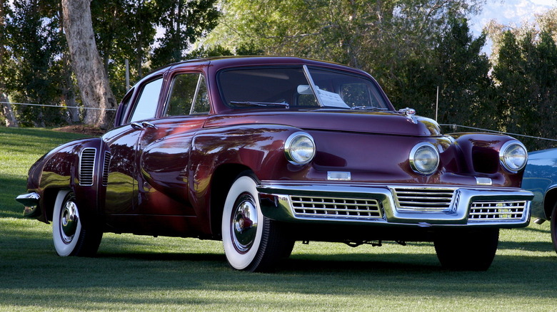 Red 1948 Tucker 48 "Torpedo" sedan seen from right front parked on grass