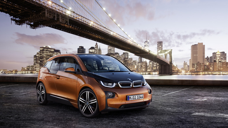 BMW i3 front 3/4 view parked in front of a cityscape