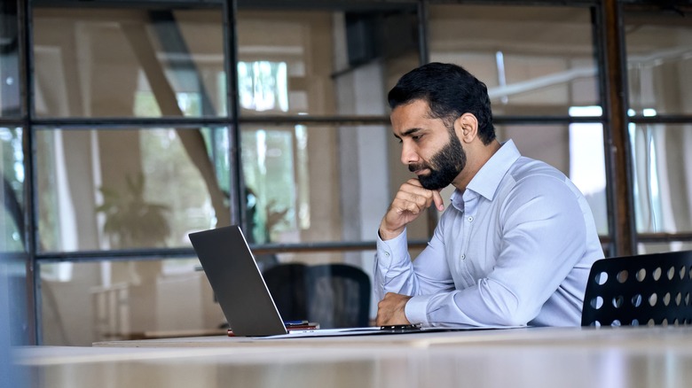 man using laptop in an office