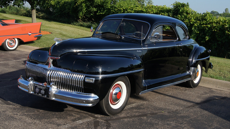 1942 DeSoto Club Coupe in black seen from left front parked at a car event