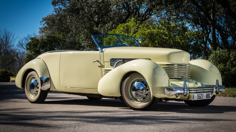 Cream-colored Cord 812 convertible seen from right front with top down