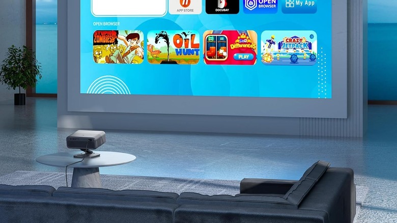 Small projector on a table displaying movie titles on a screen