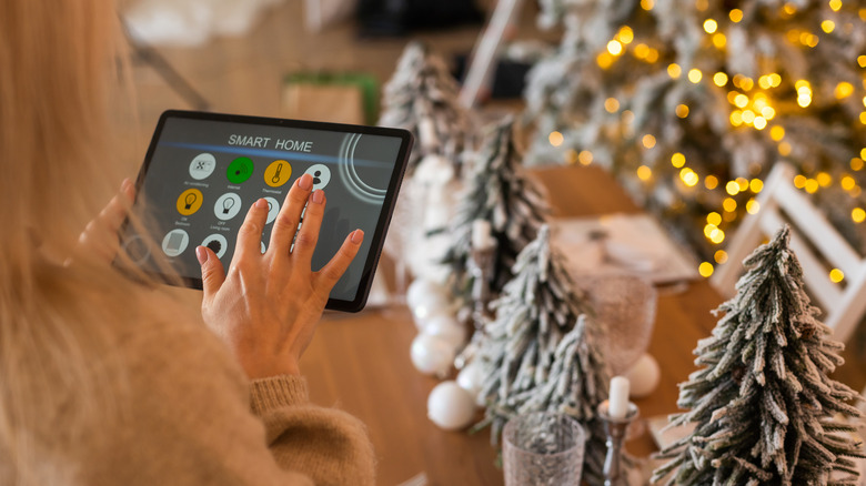 Person using a tablet in front of a Christmas tree