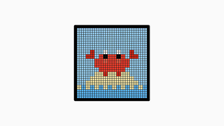 An unbranded LED screen displaying a cartoony, pixel art crab on a small island of sand