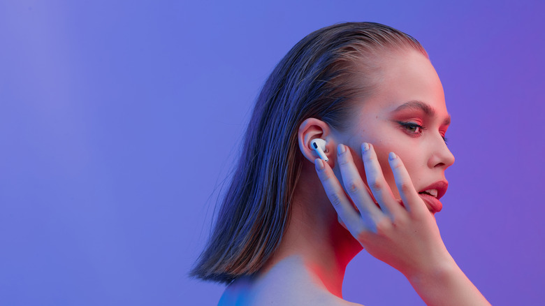A person tapping their AirPods