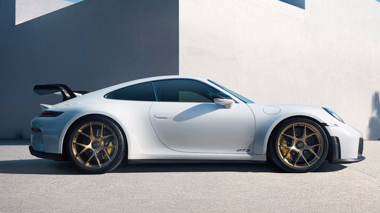 White 2025 Porsche 911 GT3 in front of white building promotional image