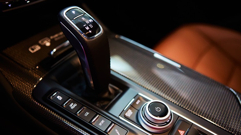A modern car's center console, featuring a sleek gear shift knob 