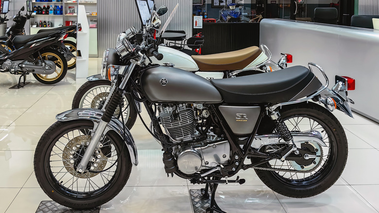 An Image featuring classic Yamaha bikes lined up in a showroom, ready to be sold.