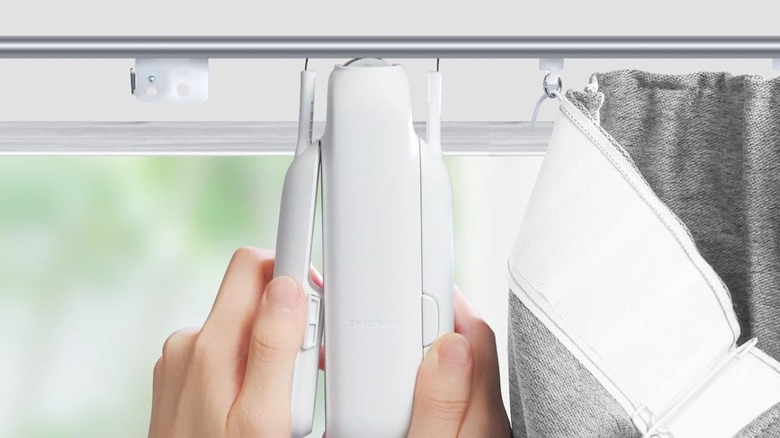 hands holding SwitchBot curtain opener
