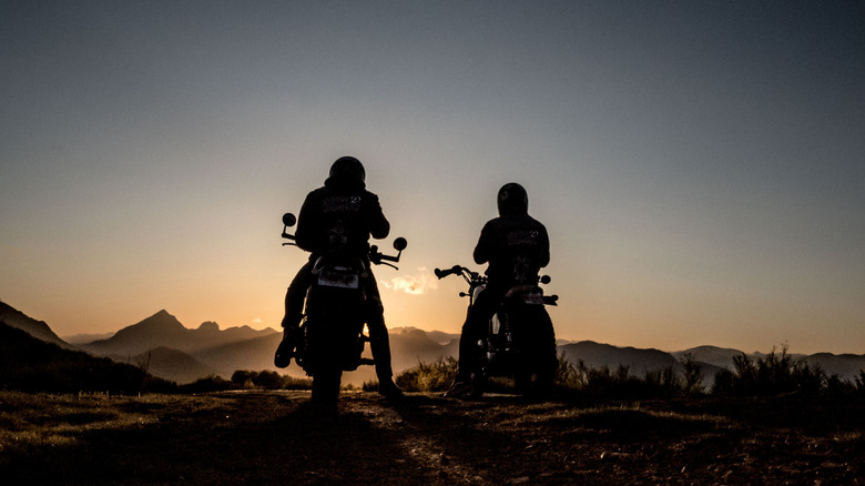 2 motorcycle riders with sunset background