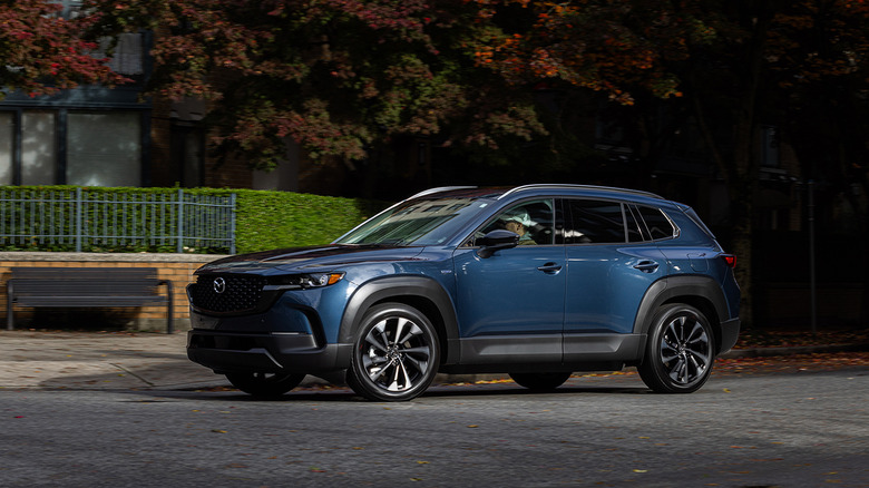 A dark blue 2025 Mazda CX-50 driving