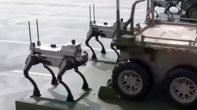 Two robot wolved mounted behind another autonomous vehicle on the back of a truck.