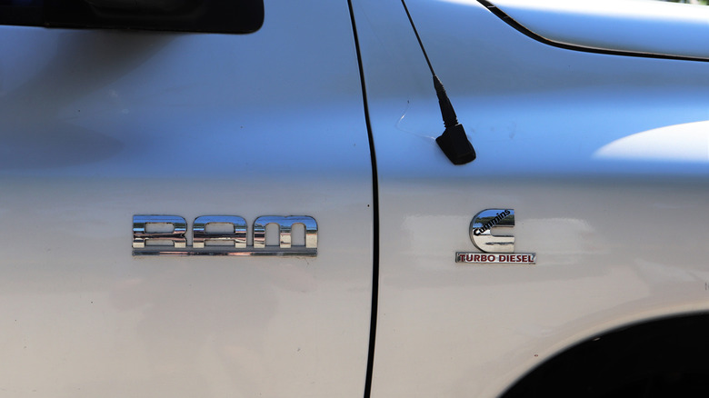 Side of a silver RAM pickup truck with the Cummins turbo diesel logo on the side