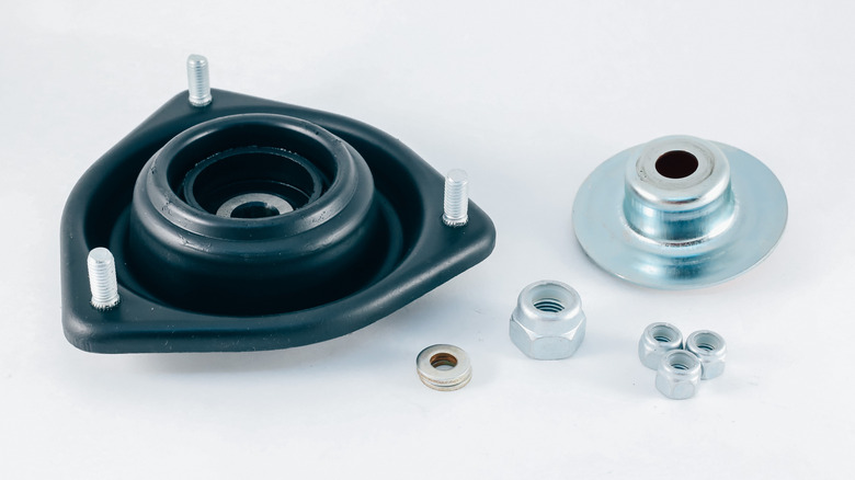 A strut bearing plate housing a bearing, with other parts nearby
