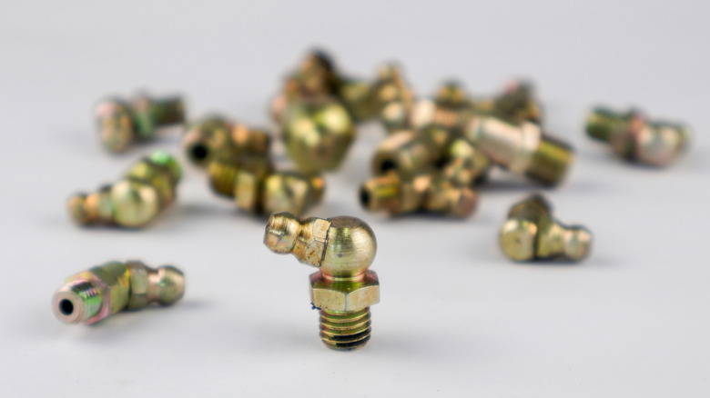 zerk fittings scattered on a grey background