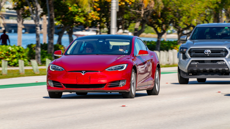 A red Tesla Model S driving on the Rickenbacker Causeway in Miami, FL.