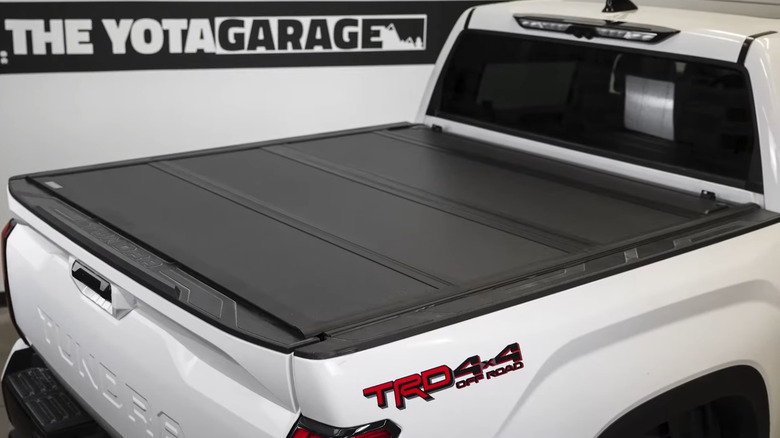 White Toyota Tundra bed with OEM Toyota tri-fold tonneau cover installed
