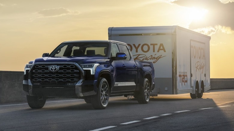 Blue Toyota Tundra towing a trailer at sunset