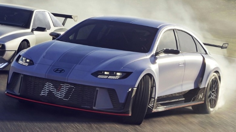 A sleeklow-slung silver 2026 Hyundai Vision 74 showing off its wild aero around a misty racetrack.