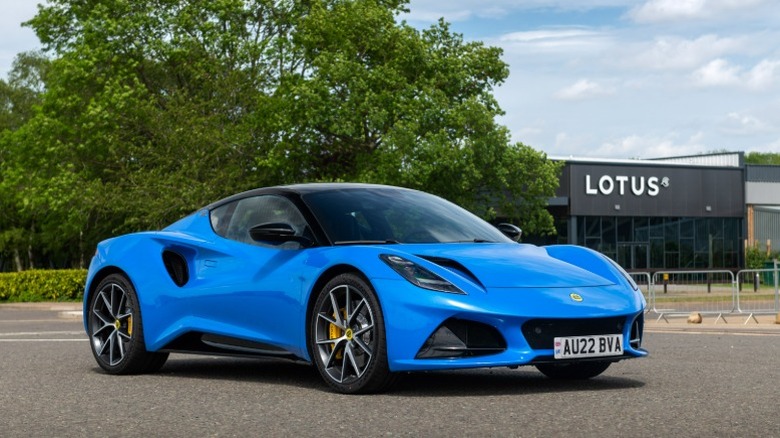 Blue Lotus Emira parked in front of a Lotus building